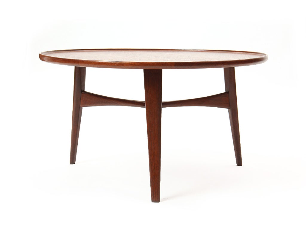 A round low coffee table on three tapered dowel legs with three point stretcher. Manufactured by Willy Beck.