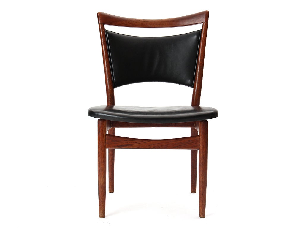 A sculptural oak framed model 86 dining chair having a rounded teak handle back and original black leather upholstery.
