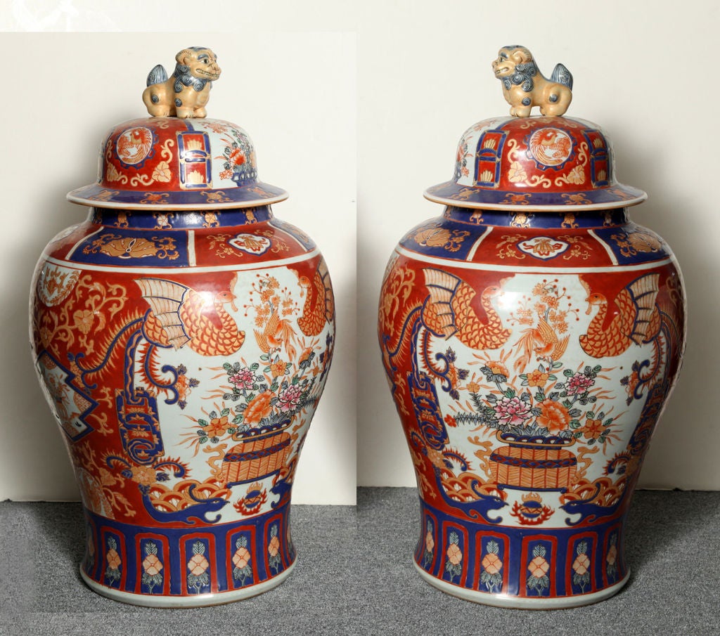 OF BALUSTER FORM, WITH TYPICAL IMARI DECORATION PREDOMINANTLY IN IRON RED AND BLUE AND RESERVES CENTERED BY BOUQUETS OF FLOWERS, THE COVERS WITH FINIALS MODELLED AS FU-DOGS, INSCRIBED 