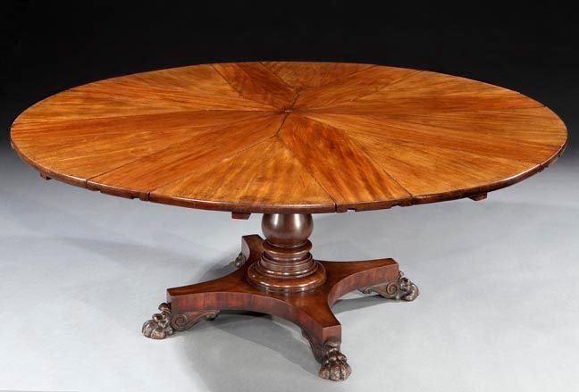 The segmented top expanding to receive eight original leaves. The plain cross-banded frieze above a blauster pod on a platform base with paw feet. Raised on original brass castors.  With cast iron mechanism and bearing an original circular engraved