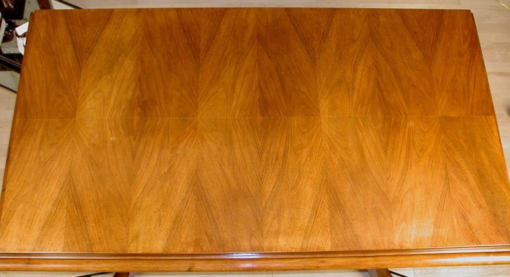 A pale walnut centre table, the legs fitted with nickel-plated mounts; the top with butterflied and bookmatched veneers.