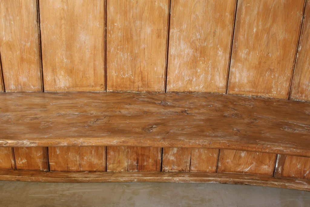 This rustic 19th century English bench is a rare antique treasure. The sweeping curvature of the back and the natural wood patina accentuate its effortless beauty and charm. This versatile piece is a perfect accent to your indoor or outdoor decor,