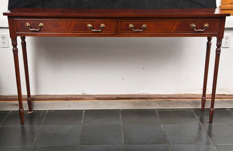 Made for us in England, this console in flame mahogany is just the right depth to squeeze into that hallway or tuck behind the sofa. With Regency touches like ebony and satinwood string inlay and narrow, turned legs, it is able to bridge many