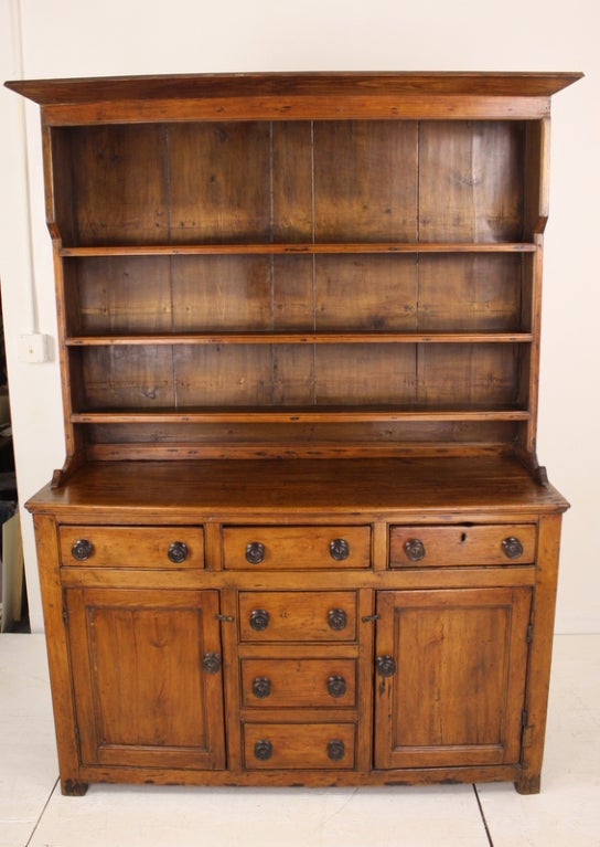 An exceptional early dresser from Wales. The deep, rich honey color of the pine is accentuated by the old, dark knobs. The configuration of drawers and doors with graded shelving which allows large platters on the top shelf all make this piece a