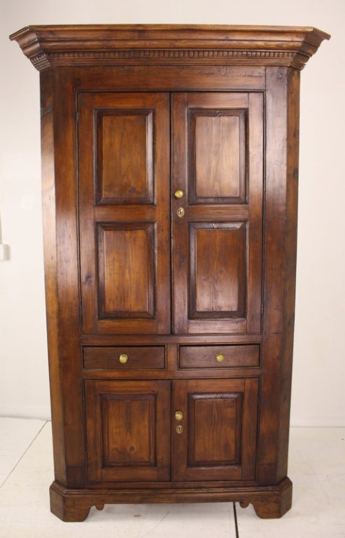 Early corner cupboard from Scotland. A very high quality antique.  The dark pine is rich in color and patina. The larger cabinet doors on top open up to two lovely shaped shelves, recently painted in a soft green. The smaller bottom cabinet opens up