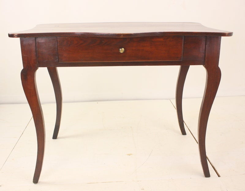 Antique serpentine table from the Basque region. The piece is deep rich reddish old paint. Lovely cabriole legs. One drawer with a little brass handle. Quite an interesting piece, unique.  The right height for a desk and a lamp.