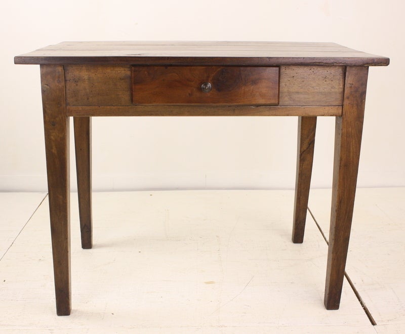 A large walnut side or lamp table/desk from France, with a very pretty and complimentary fruitwood drawer.  The dimensions on this table would also make it right as a small desk or writing table, great old workshop markings on the top-lots of