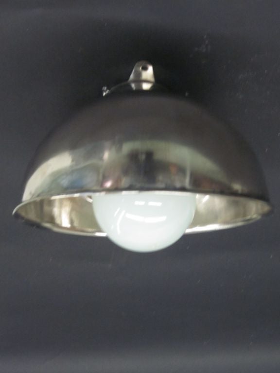 Pair of French Mid-Century Modern, Marine Industrial wall lights or ceiling flush mount fixtures in the style of Jean Prouve with thick milk glass globes set into circular stainless steel frames. 

The pieces can be oriented up or down and work on