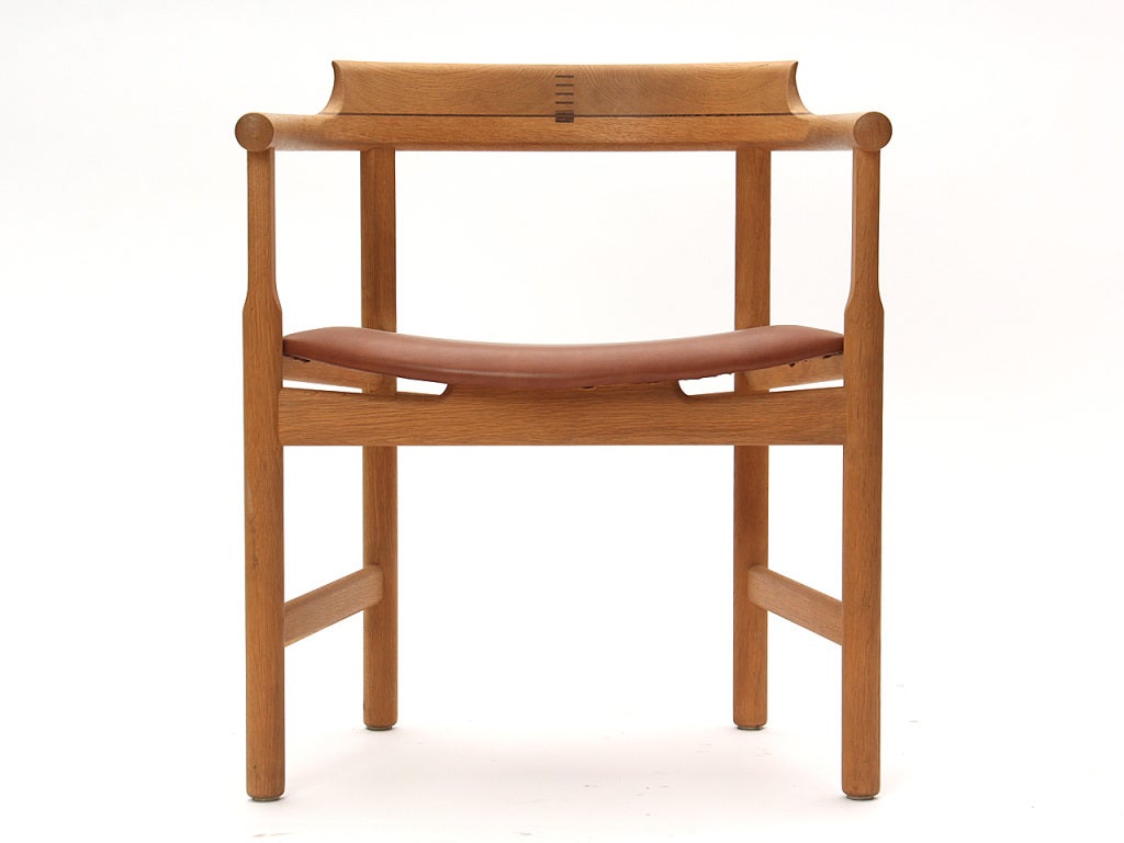 An oak armchair with a flared out horseshoe shaped back and arms and wenge accents.