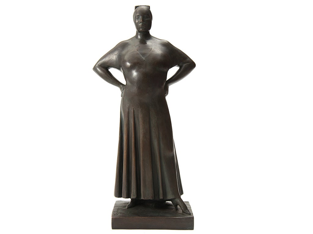 A bronze sculpture of a woman standing arms akimbo.