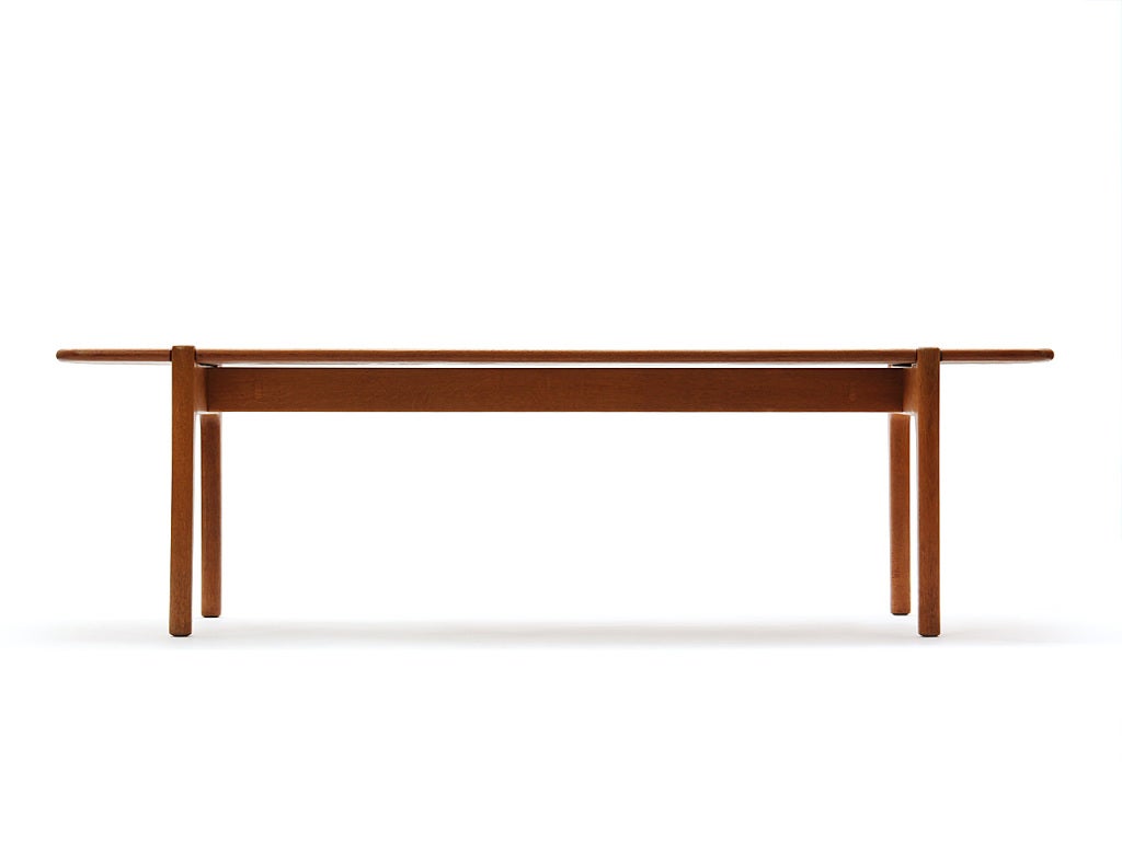 A low table or bench with a reversible solid teak top on an oak base.