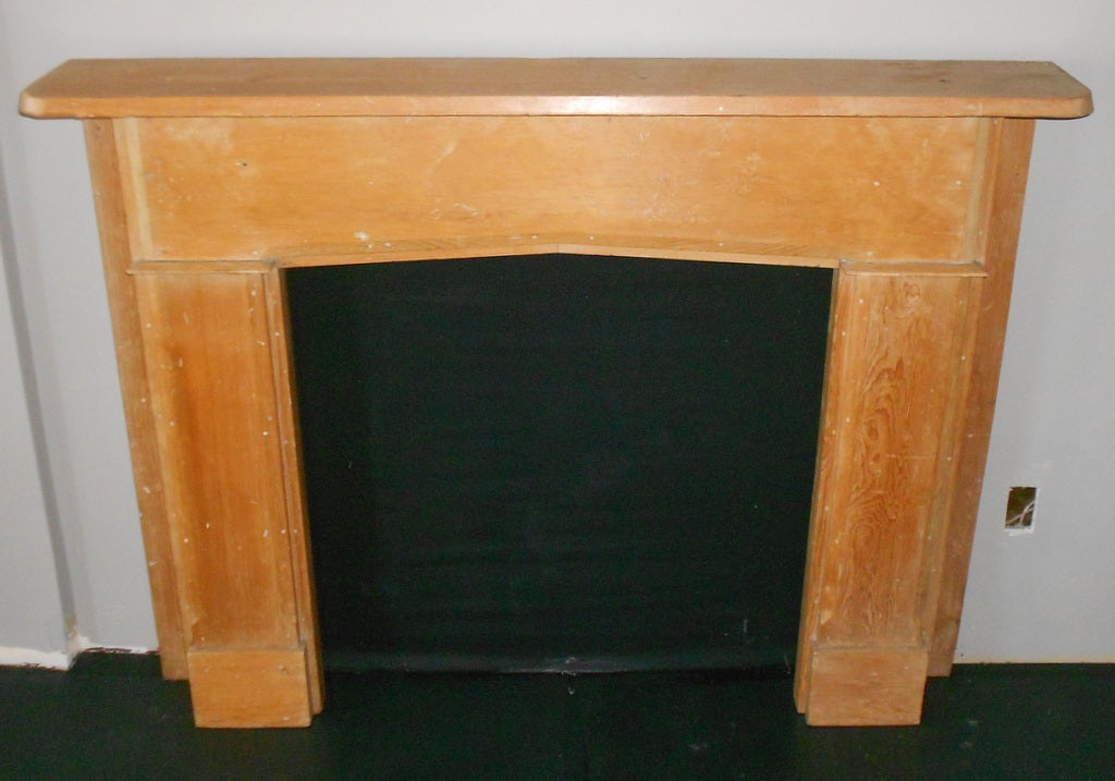 This fireplace mantle and surround has a Shaker-like simplicity of line and design. It is hand crafted from ponderosa pine with square nails and curved inch-thick top. It is in good, solid  condition for its age and could be easily refinished.