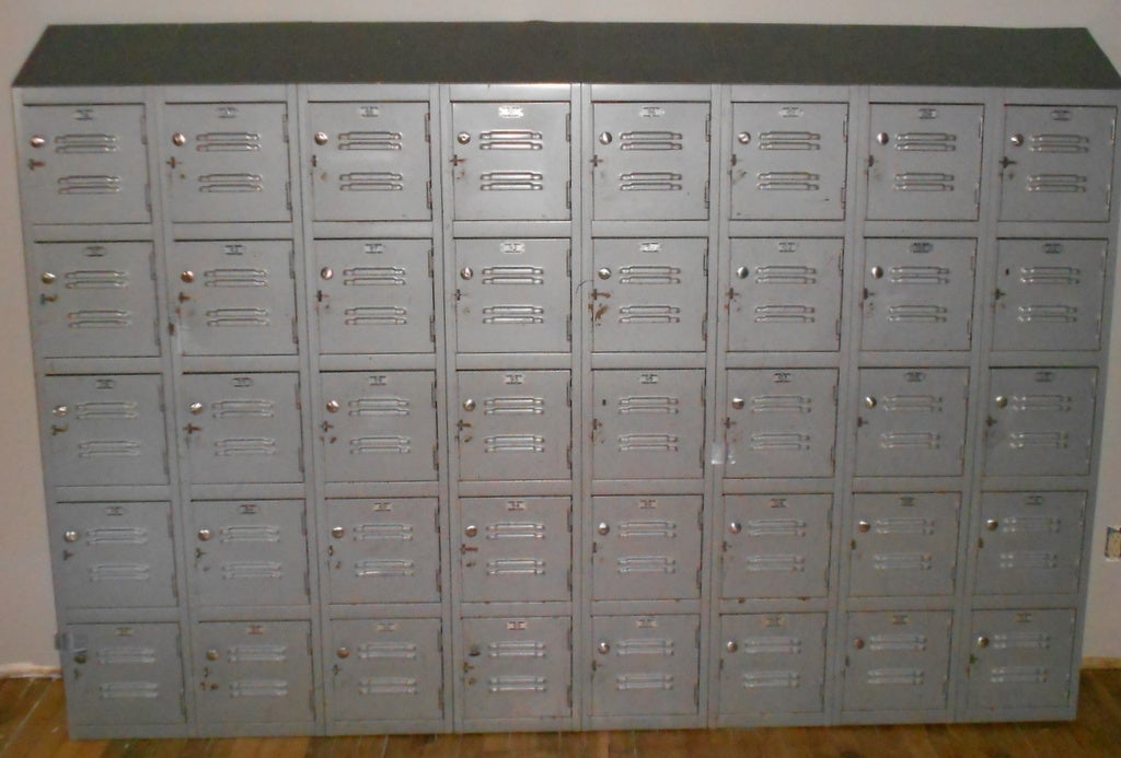 This impressive bank of steel storage lockers in gray paint hails from a Mid-Western factory where working folks stored their personal gear during shifts. The unit is in excellent shape with very minor rusts spots. Each numbered locker is a foot