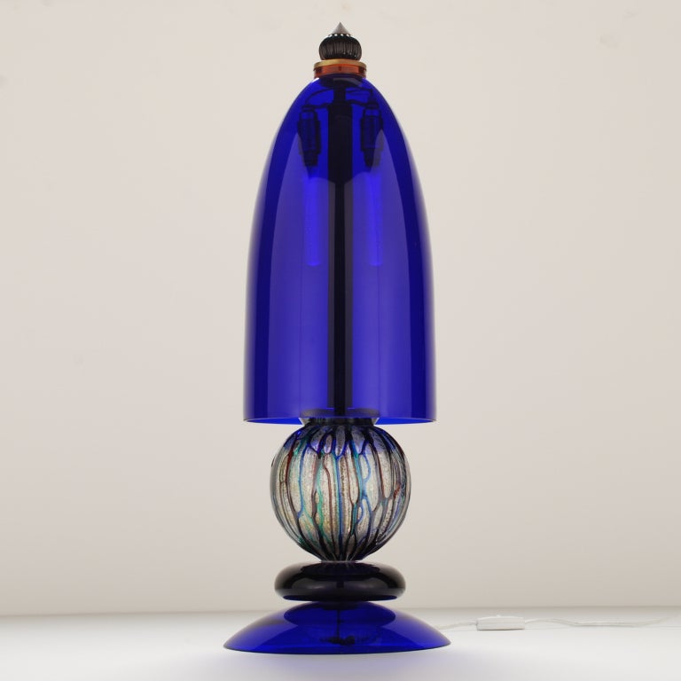 This striking Murano glass lamp has a large Cobalt Blue glass shade and a textured glass orb base, topped with fluid lines of red, blue and green. This was a difficult piece to photograph as the studio lights made the cobalt blue appear lighter and