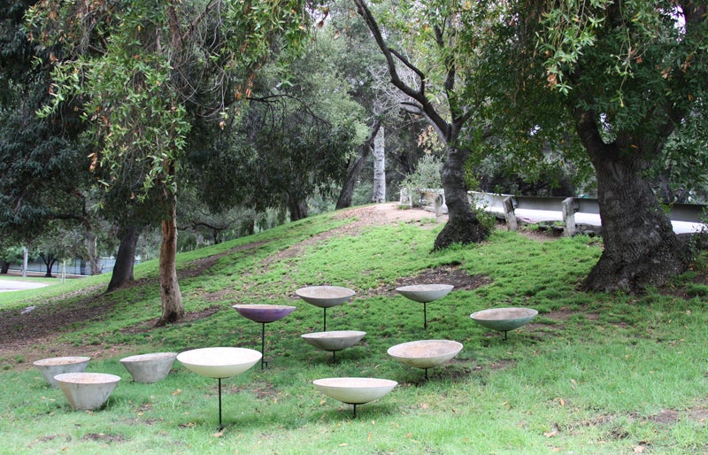 Fourteen hemispheric (with fourteen stands, varying heights) and four conical planters.  Planters are  made of a cement composite and the hemispherical planters sit upon sturdy steel bases, like stems.  The bases are different heights and as a set