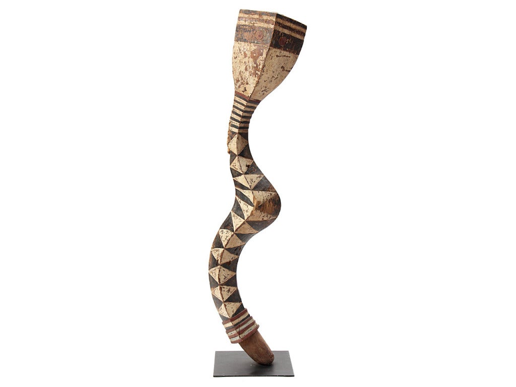 A sinuous carved wood “Bansonyi” snake sculpture with black, white and red polychromed geometric decoration, from the Baga tribe in Guinea.