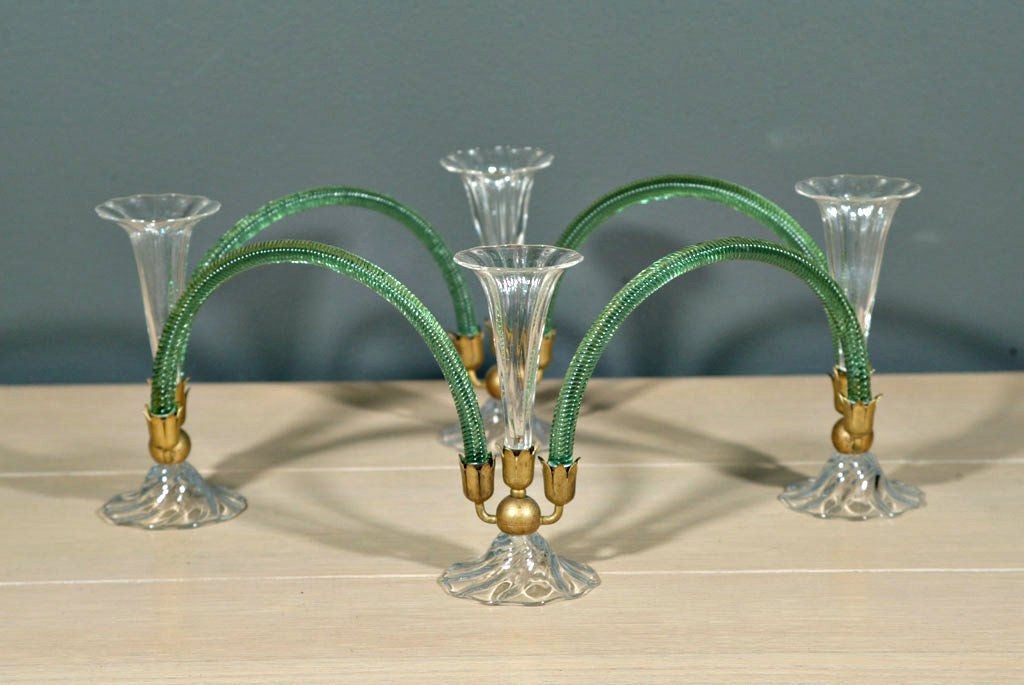 An elegant and quite unique 1930s Murano glass candelabra / epergne consisting of 12 total individual components: 4 flared bases with tri-arm supports in gilt bronze, 4 trumpet-shaped holders and 4 green, ribbed glass 