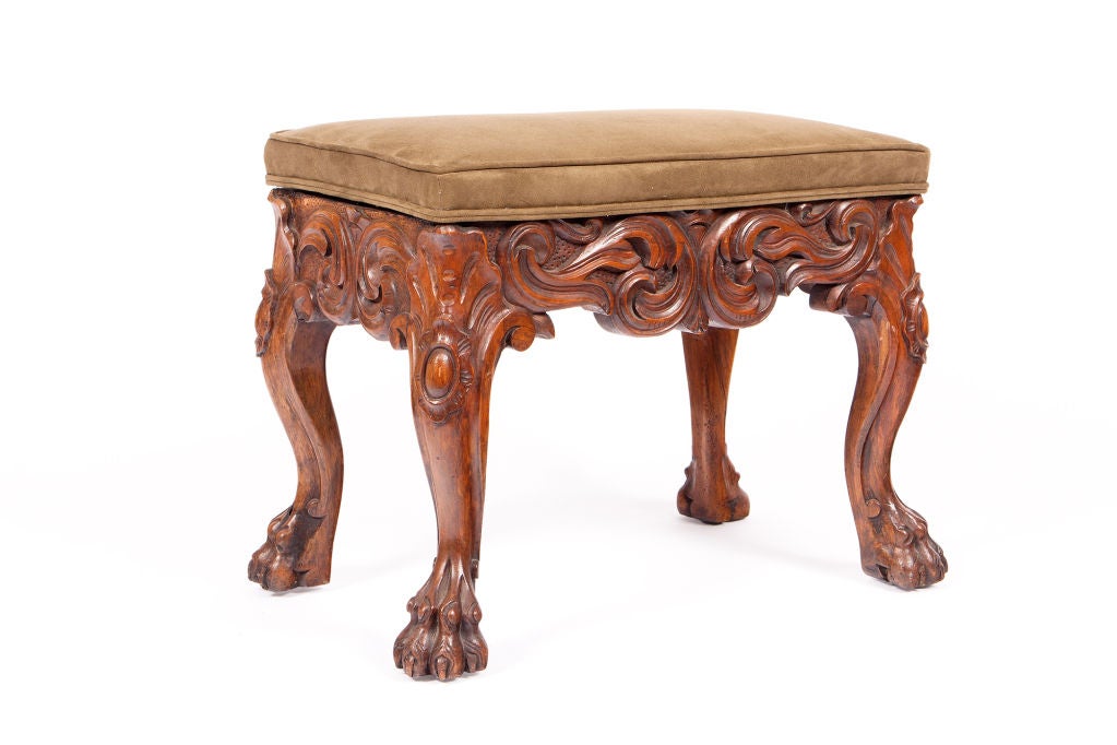 19th century heavily carved mahogany stool on paw feet.