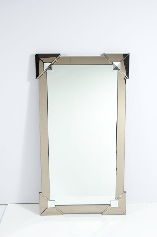 Modernist mirror with Venetian<br />
style shield design. Mirror has<br />
hand beveled borders comprised<br />
of smoked mirrors with diamond<br />
cut mirrored inserts in pale<br />
turquoise.
