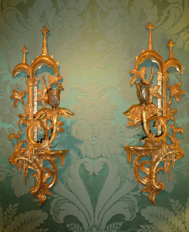 Rare and fine pair of antique Chippendale period carved gilt wood rococo chinoiserie wall lights, with double arched pagoda tops above twin reticulated pilasters with capitals and swirling leaf carved branches, each with a single scrolling candle