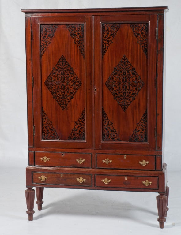 The cabinet is of a very good quality and is in three sections. It has a pair of door panels on the top with a thick ebony moulded cornice and a pair of ebony columns on the sides. The door panels at the top and bottom and the drawers are profusely