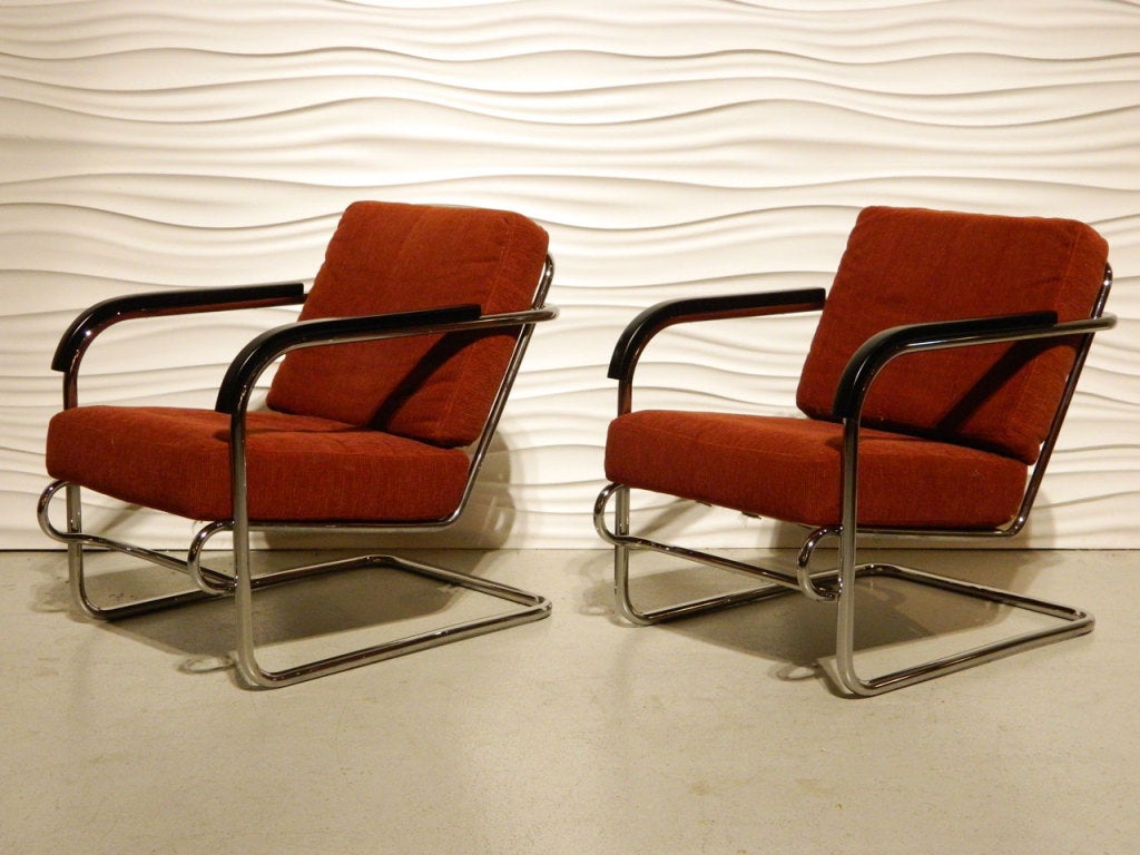 Pair of Deco Chrome cantilever loungers with wooden armrests.
