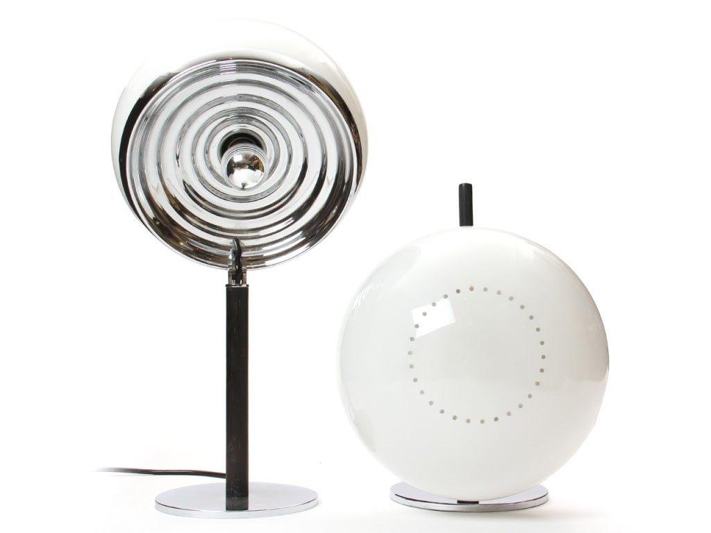 A pair of half-dome articulating table lamps. The white shade houses two bulbs under which a single bulb protrudes from a chromed rippled reflector. Black ribbed handle and stem. Chromed plate base. Lodovico Meneghetti and Giotto Stoppino.