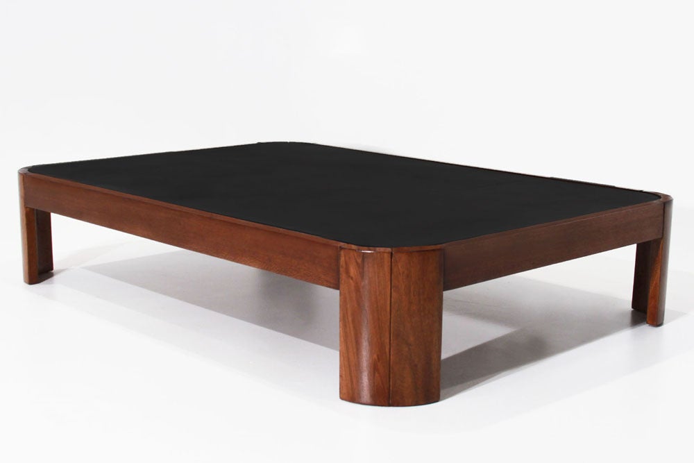 Rectangular exotic wood coffee table with inset black leather top from Brazil. Wood has rustic qualities as shown in the photos but has been refinished nicely, and the curved corners add interest to a simple design. A matching smaller square coffee