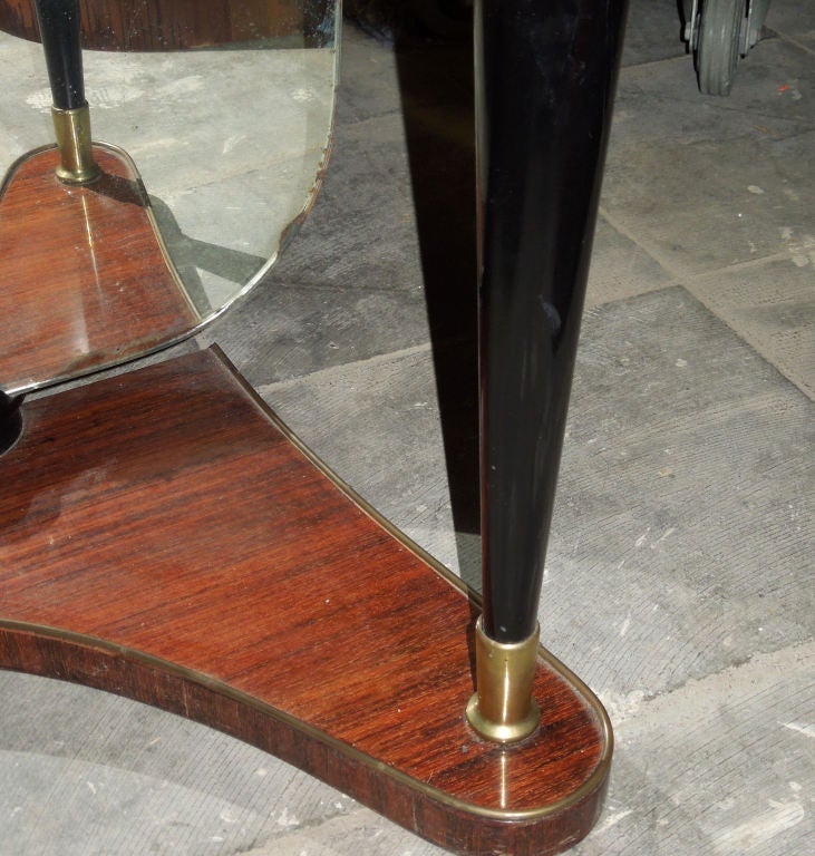 Dark rosewood veneered console-vanity with one glass shelf and two smaller gilded shelves.The big mirror takes part of the console and fixed with brass hardware.Sabots en brass.