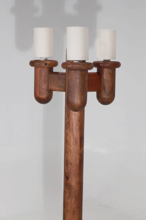 A three-pronged cactus shaped standing light fixture made of solid knotty Pine and with cylindrical shades made of linen. A handmade craft piece.

      