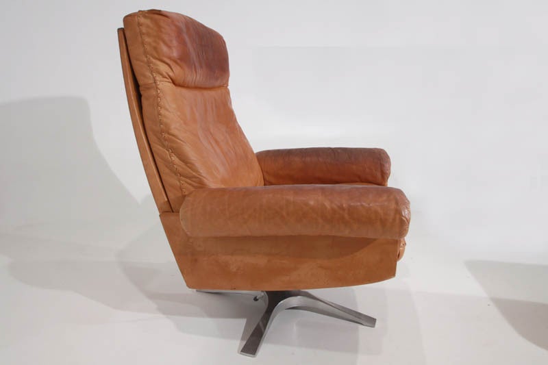 Mid-20th Century Swiveling caramel leather armchair and ottoman by De Sede