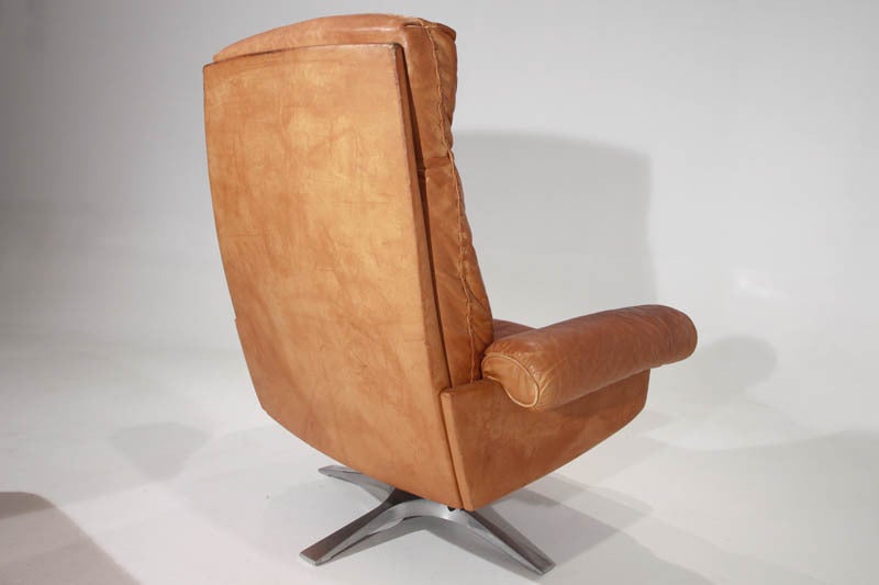 Leather Swiveling caramel leather armchair and ottoman by De Sede