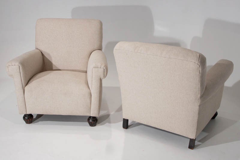 A pair of coarse linen armchairs with dark sculptural feet made of exotic Brazilian wood maintaining its original finish.

Measures: Seat height 16