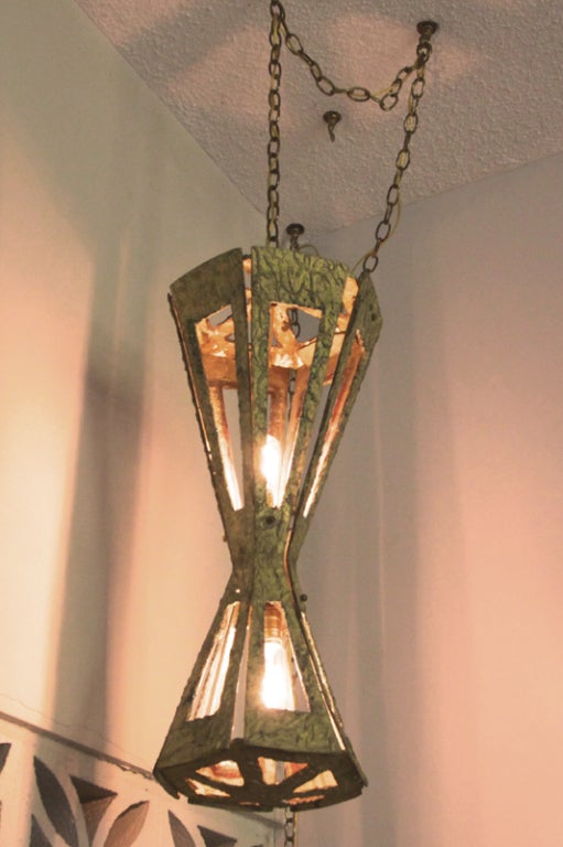 Hourglass-shaped, solid braised brass hanging swag lamp in original condition.
Many pieces are stored in our warehouse, check to see if the pieces you are interested in seeing are on the gallery floor. Thank you!

Many pieces are stored in our