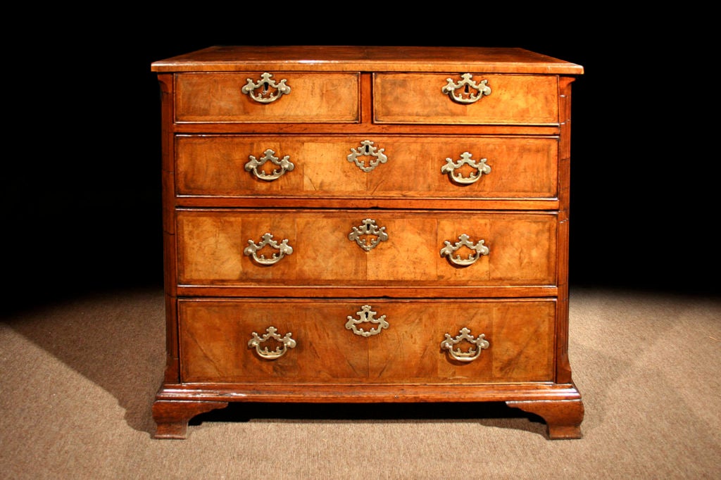 Fine early Georgian walnut chest of drawers having a rich color and patination. Note the quarter veneered rectangular crossbanded top inlaid with herringbone banding over two short and three long drawers, retaining the original brass handles and