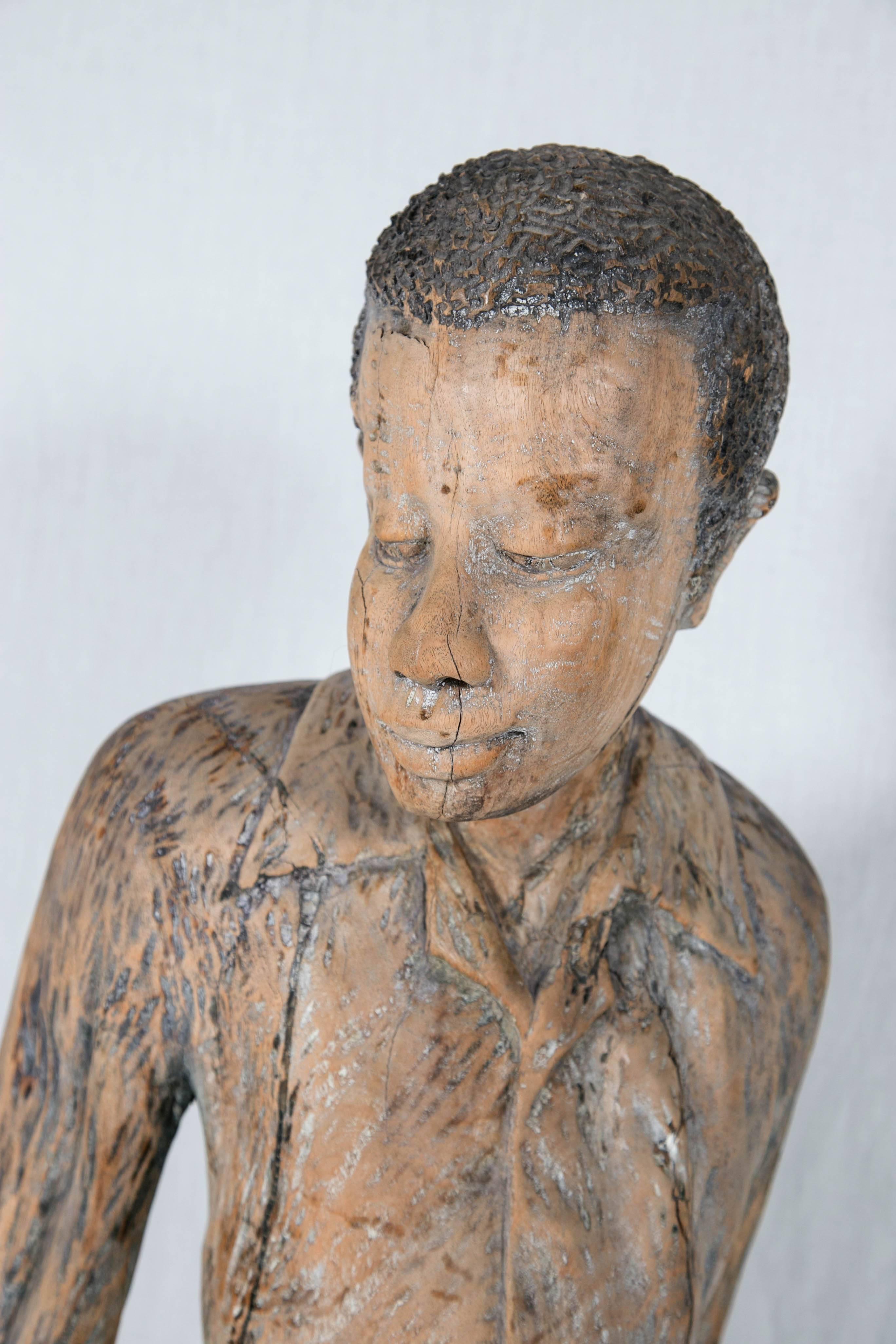 Charming folk art sculpture of a young boy. Possibly Haitian.