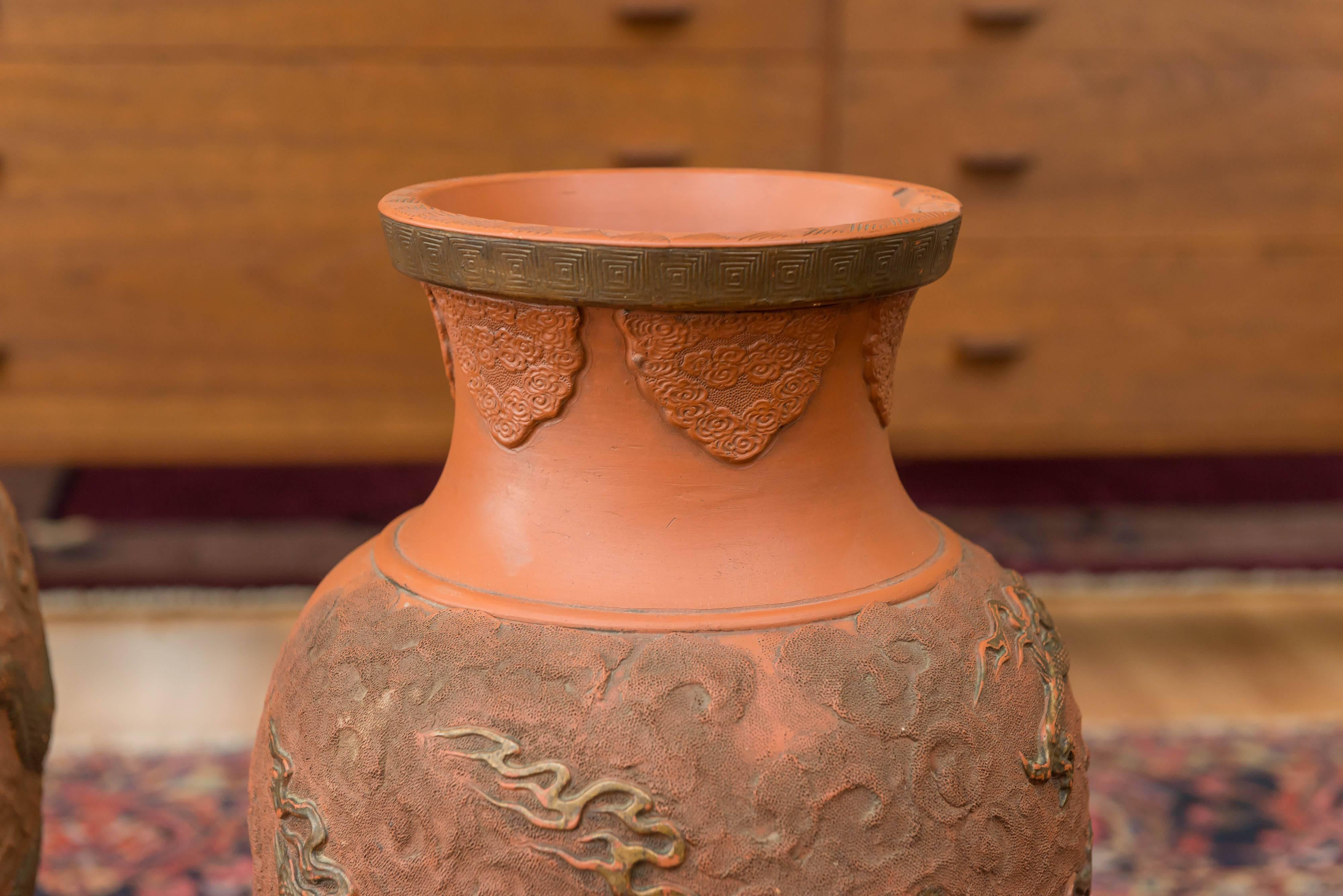Offered here are a pair of Bizen pottery vases (from Japan), with dragon design around their sides. circa late 19th century to early 20th century.