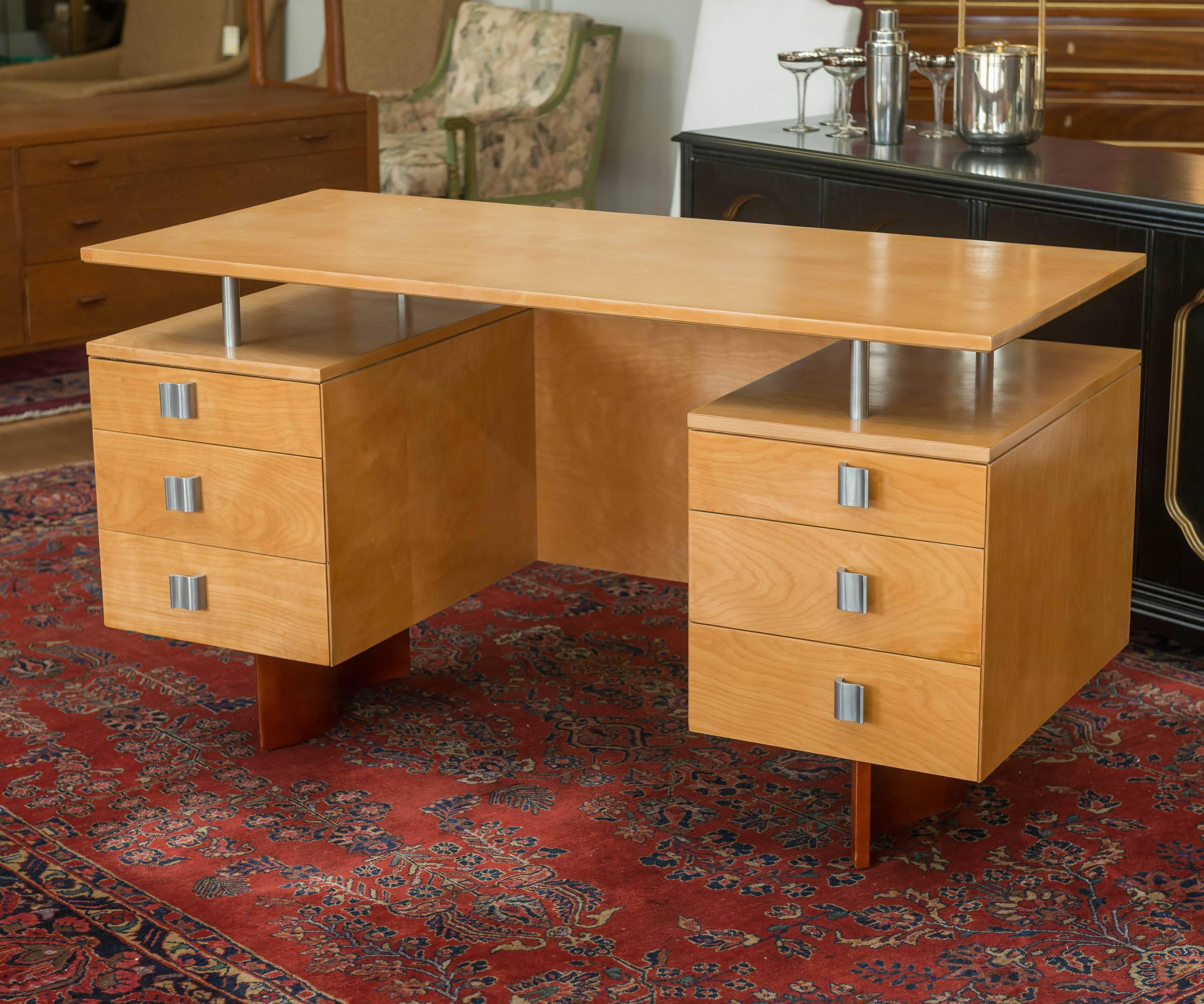 Desk designed by Eliel Saarinen for Johnson Furniture Company, circa 1940s. Birchwood construction, six brushed aluminum handles and four cylinders holding up the desk top surface.