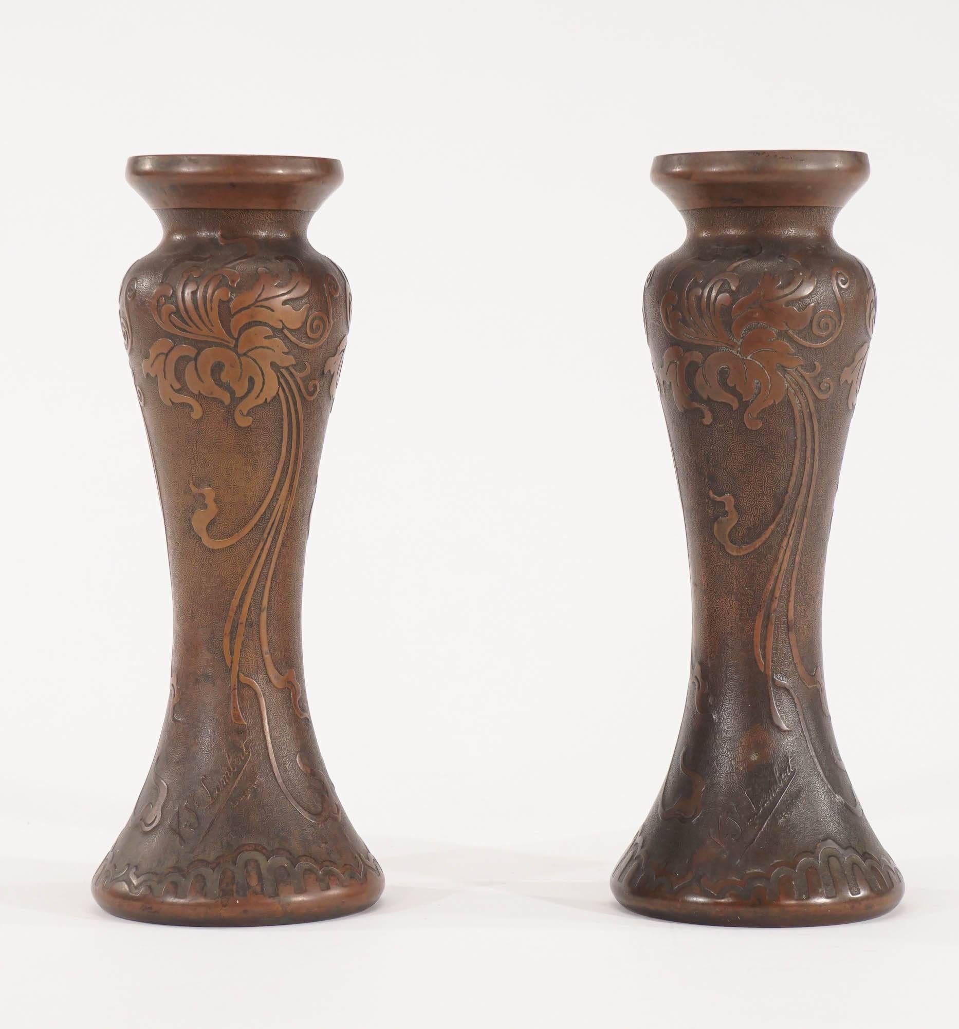 Ein hübsches Paar signierter Vasen aus mundgeblasenem Amethystkristall von Val Saint Lambert, die mit einer vergoldeten Bronzepatina überzogen sind. Der Korpus ist mit einem Hochrelief verziert, das Schwertlilien in reinen Jugendstil-Motiven