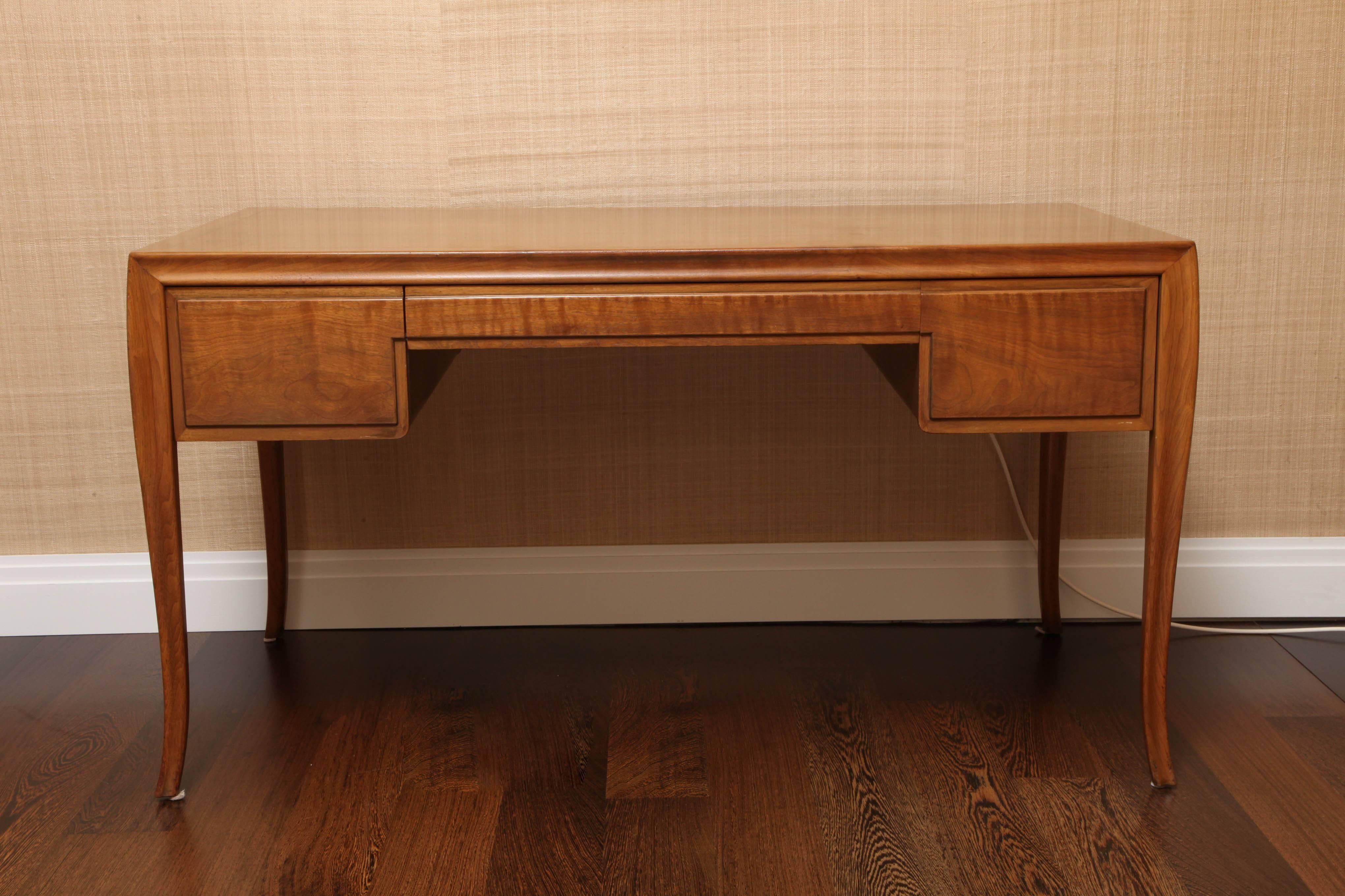 Gorgeous walnut desk designed in 1961 by the iconic T.H. Robsjohn-Gibbings (1905-1976) for Baker as part of a 32 piece collection. Robsjohn-Gibbings was heralded for his contemporary interpretations of the Classical style and this example is no