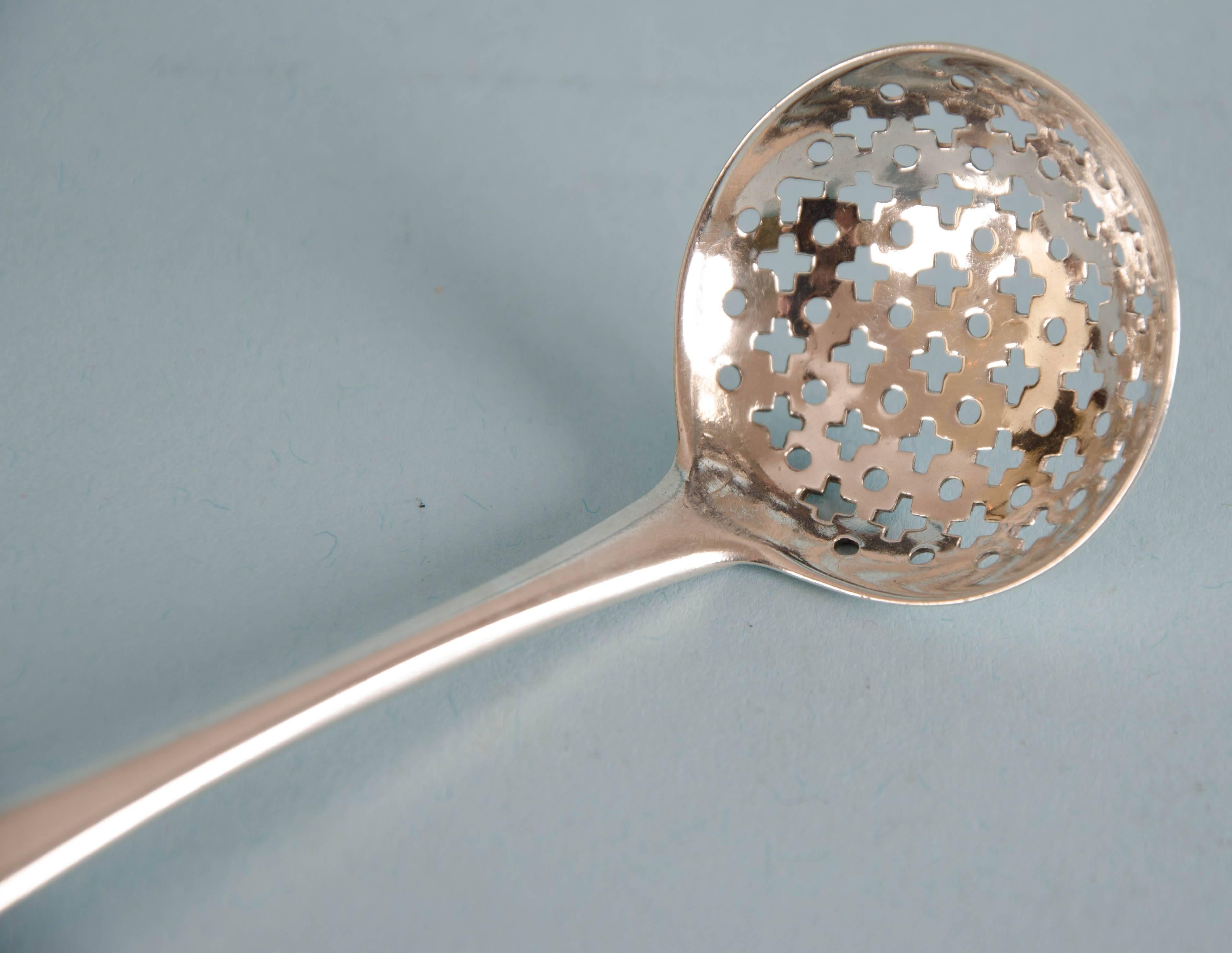 Extremely useful and attractive George III sterling silver Old English pattern sifter spoon. Made by Robert Rutland in London, 1810.
The top of the front of the handle is engraved with a contemporary family crest and a Scottish motto or battle cry