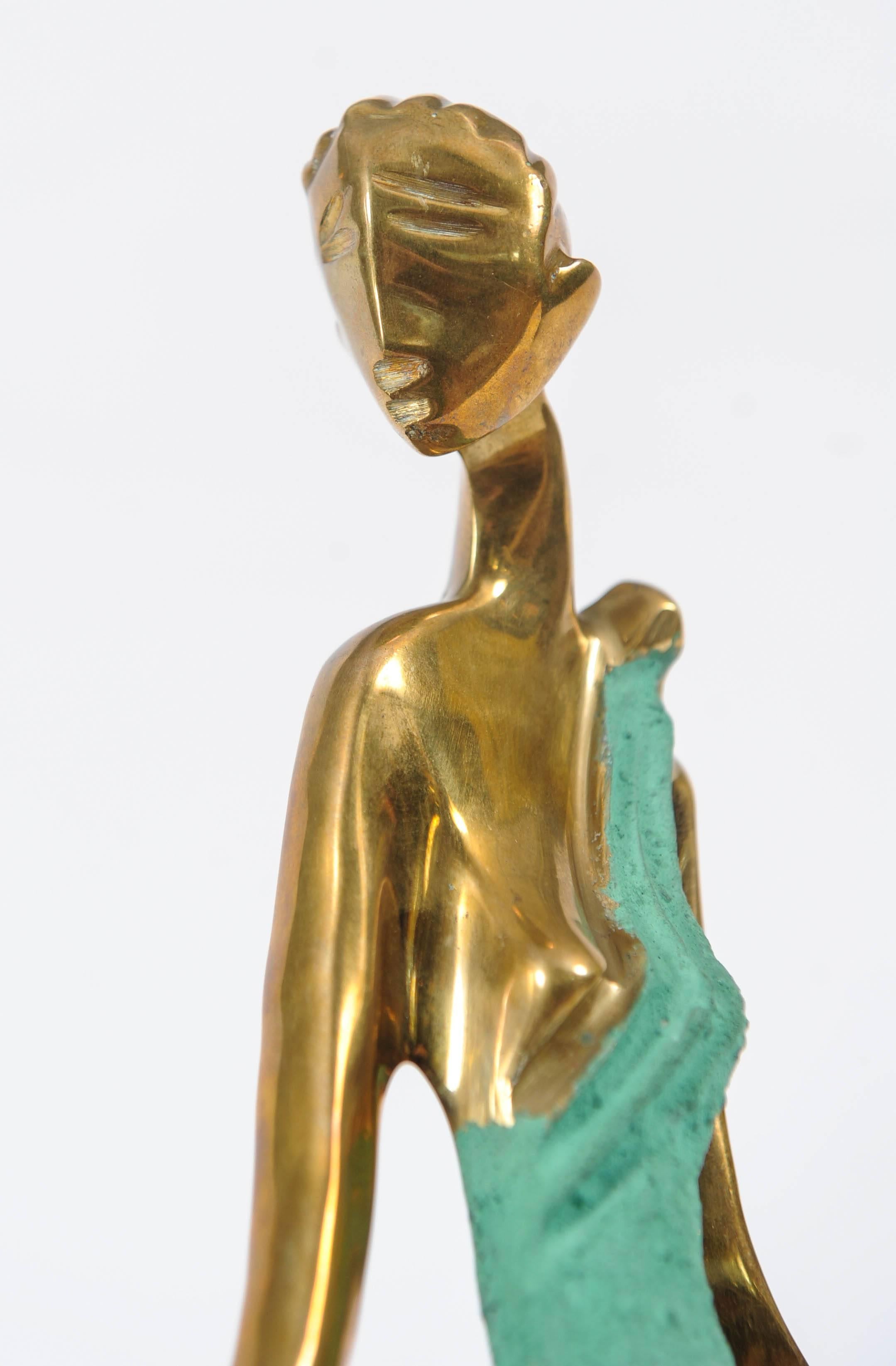 Statuette of an elegantly dressed lady made of brass on a wooden base. 