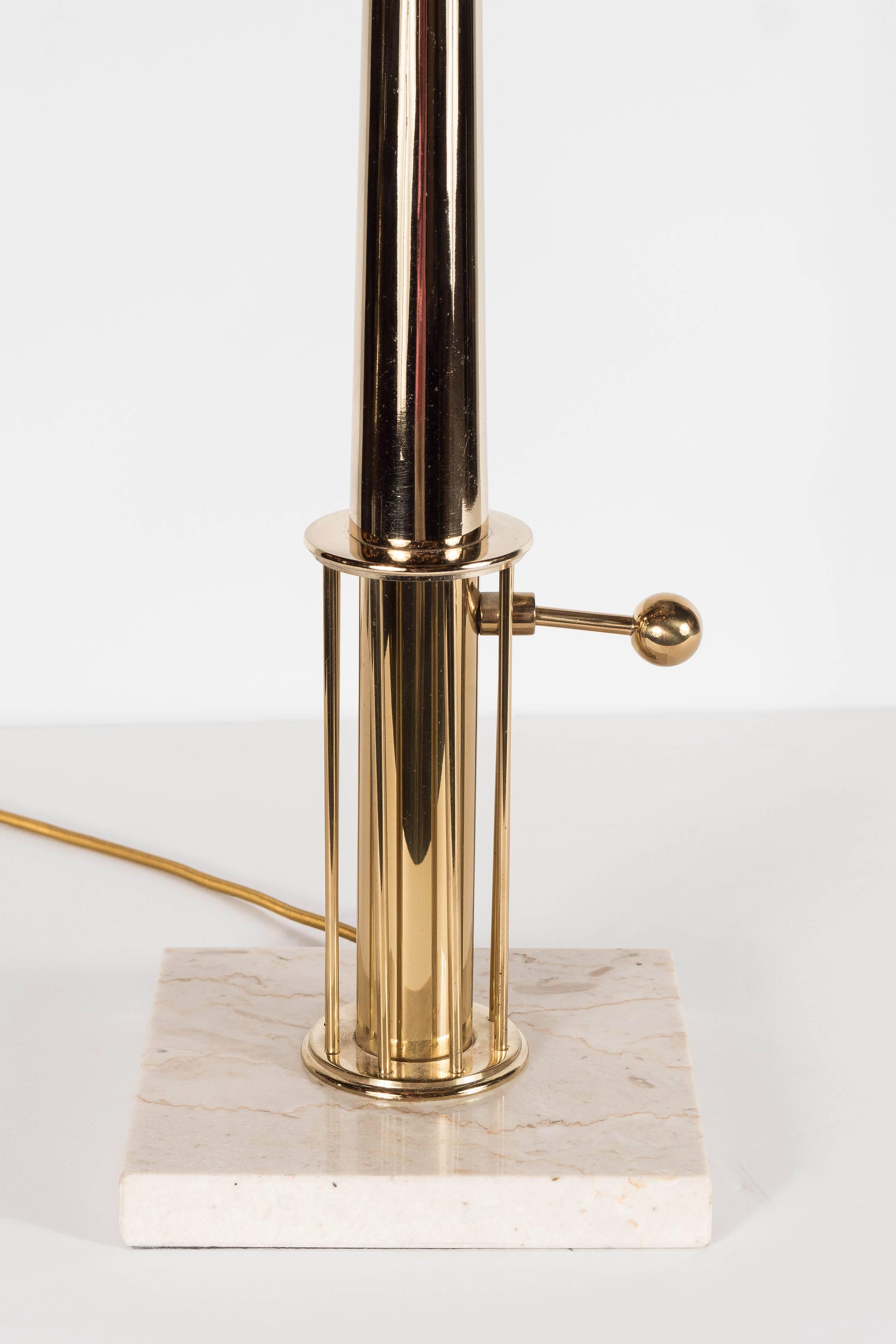 This exquisite Mid-Century Modernist table lamp by Stiffel features a brass candlestick design with sculptural elements. The square cream travertine base supports a tall tapered brass stem with architectural elements. The lamp can be switched on and