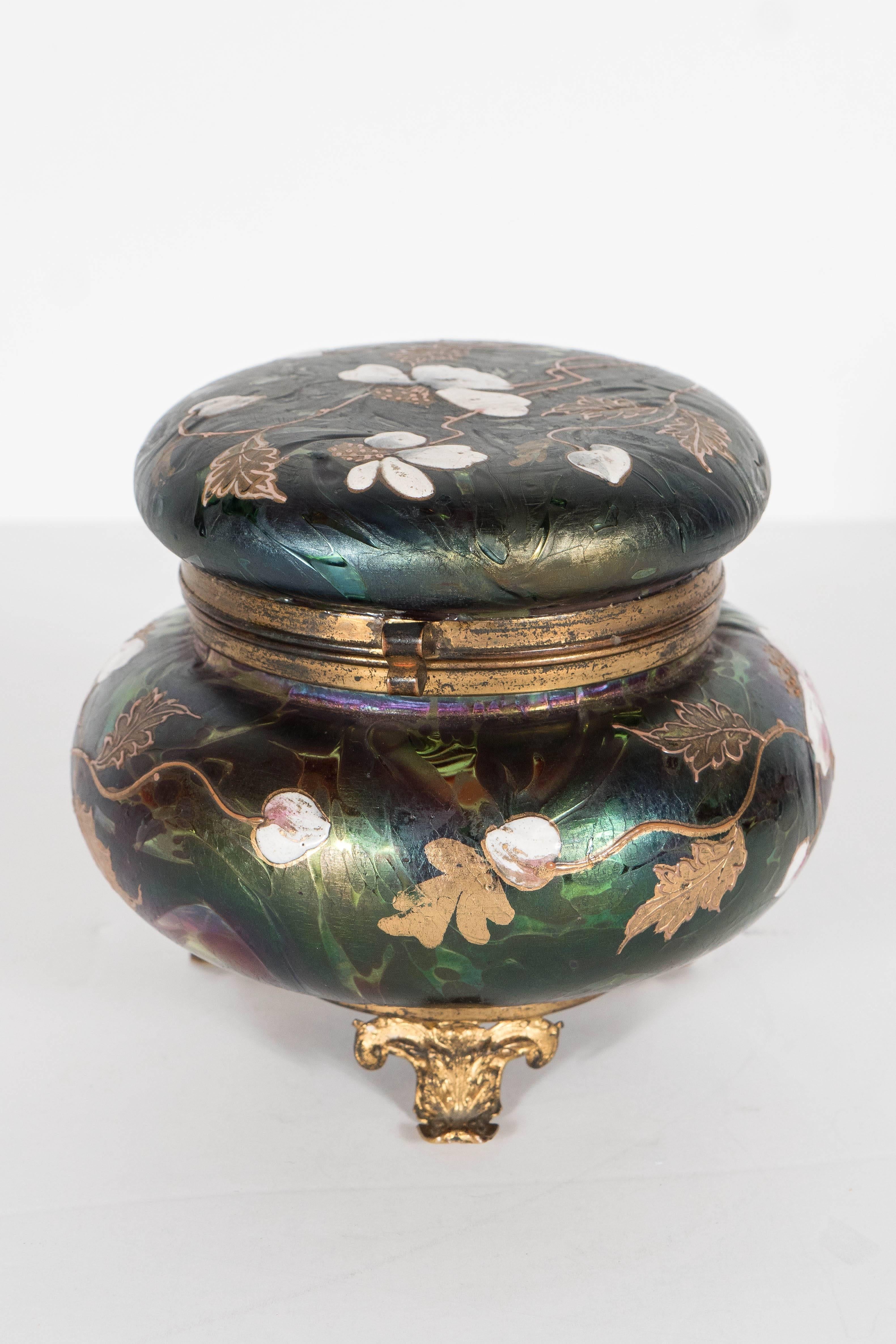 This elegant and exquisite box features a gilt base  and hinged lid with all hand painted glass with a relief scrolling floral design.  This can be used as a decorative object or functional as well. Would be great on a vanity table or a a decorative