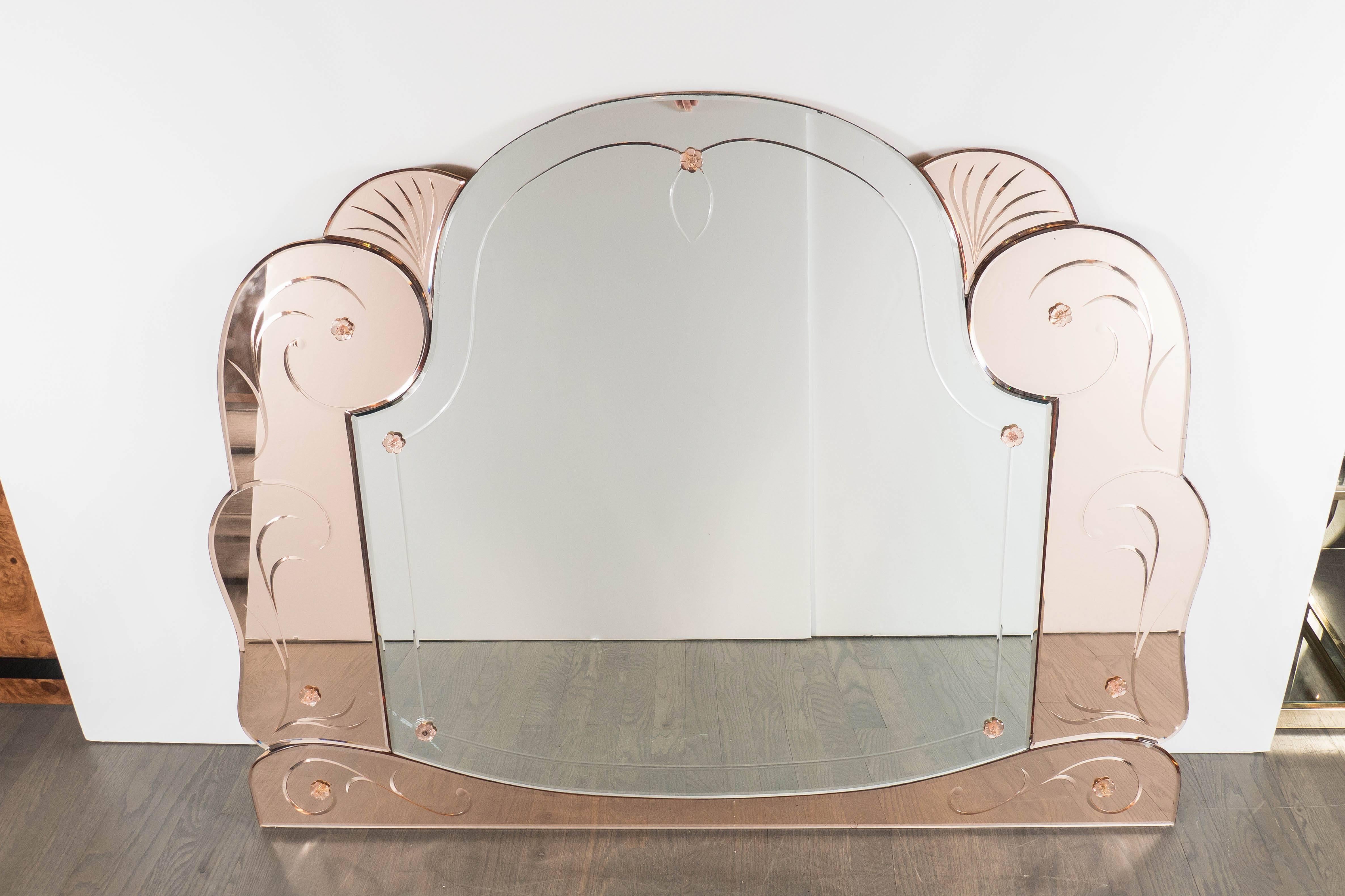 This elegant Art Deco mirror was realized in the United States, circa 1930. It features an arch form central mirror bordered by scroll and fan form panels in a layered fashion with reverse etched detailing in copper toned mirror. Each panel is