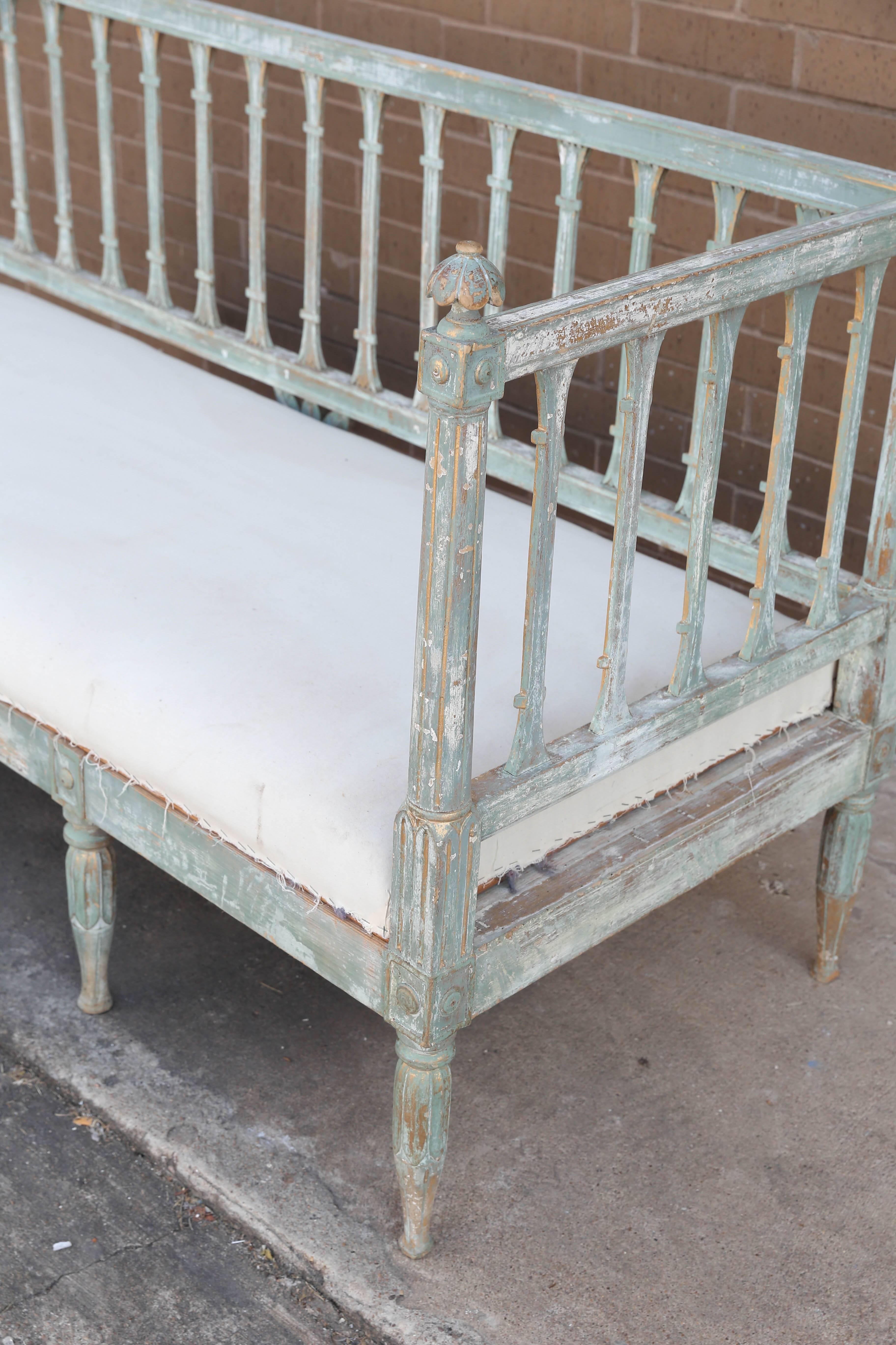 This beautiful green painted slat back sofa bench from Sweden features great hand-carved details and original muslin ready for your new upholstery.