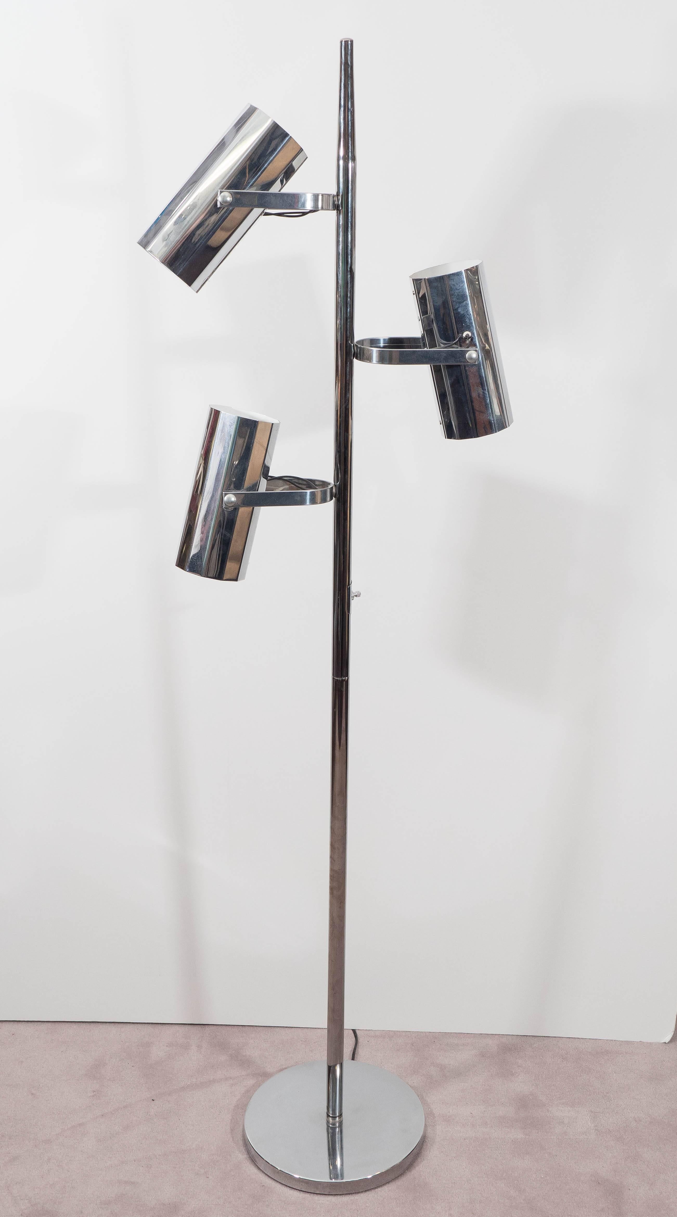 A 1970s chrome floor lamp by Koch and Lowy, produced in the US, features three cylinder-shaped pivoting shades and a round base. Good condition, consistent with age and use, with a few minor dents and scratches to the chrome surface.