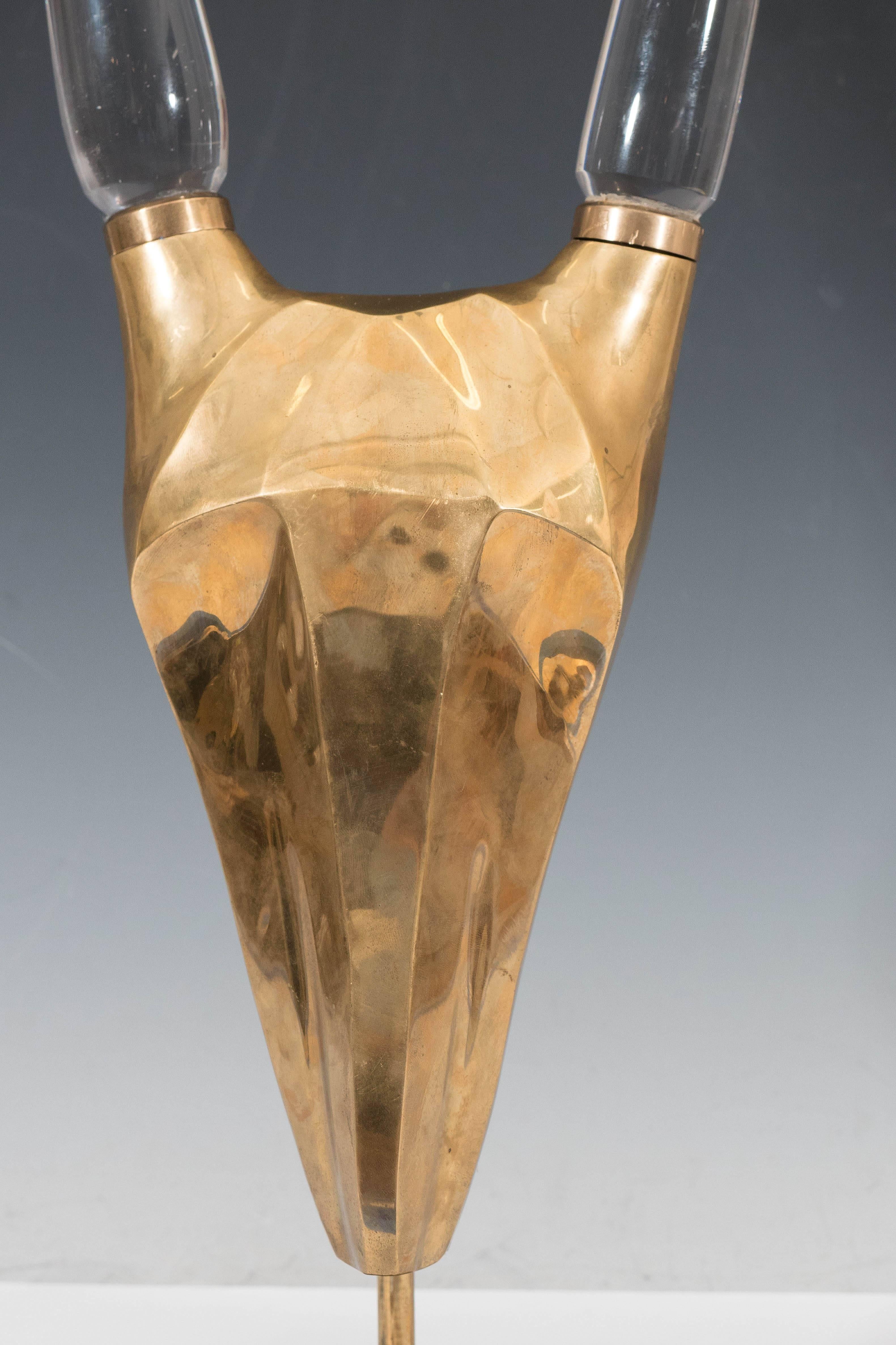 A brass sculpture of a highly modernistic abstracted antelope skull, with beautifully elongated glass horns, set above a hexagonal base. Very good condition, with no visible damages and nice age appropriate patina to brass surface, circa 1970s.