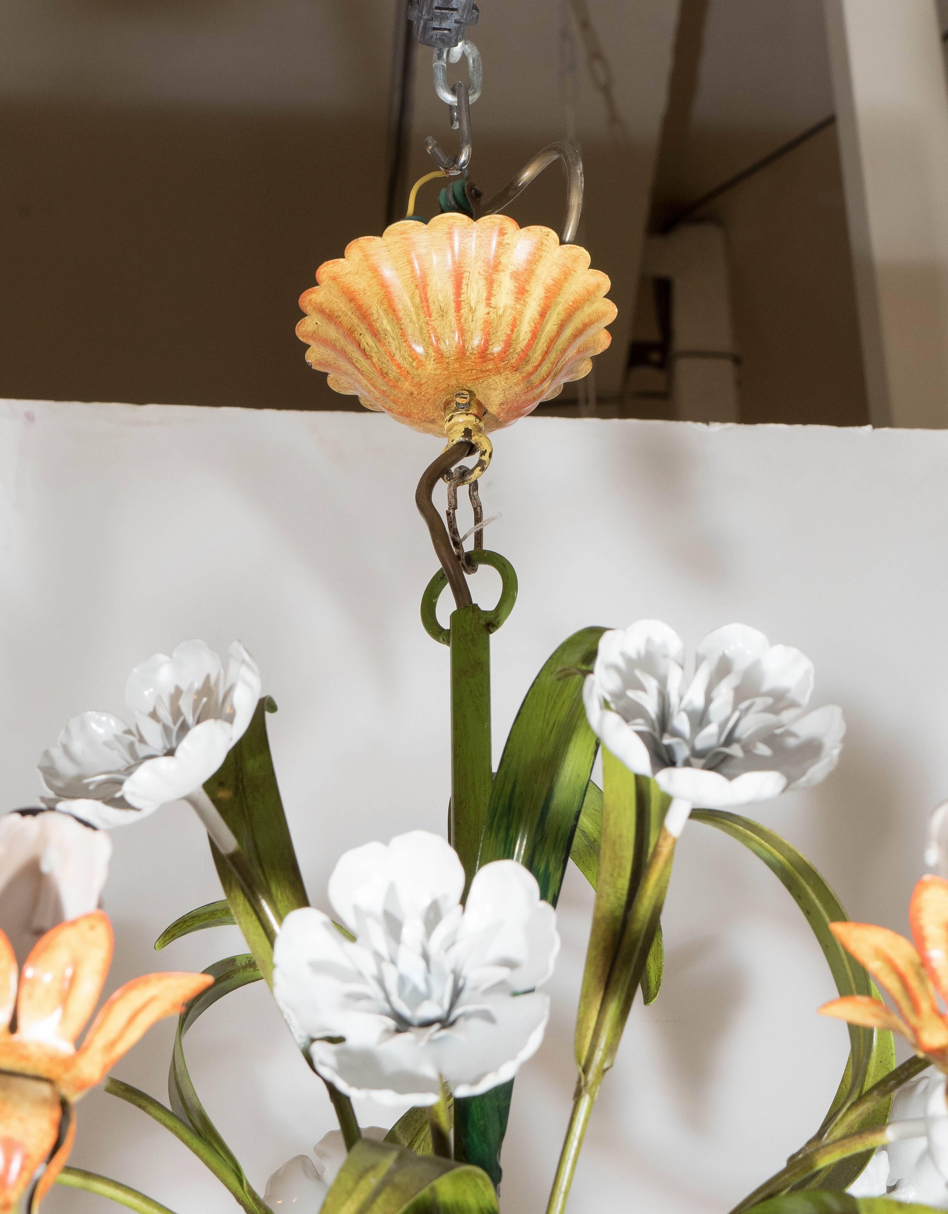A stunning chandelier with floral motif, produced circa 1970s, in beautifully painted enameled metal, with six decorative curved arms, each supporting a light, with plastic socket covers, detailed with faux dripping wax. Very good condition,