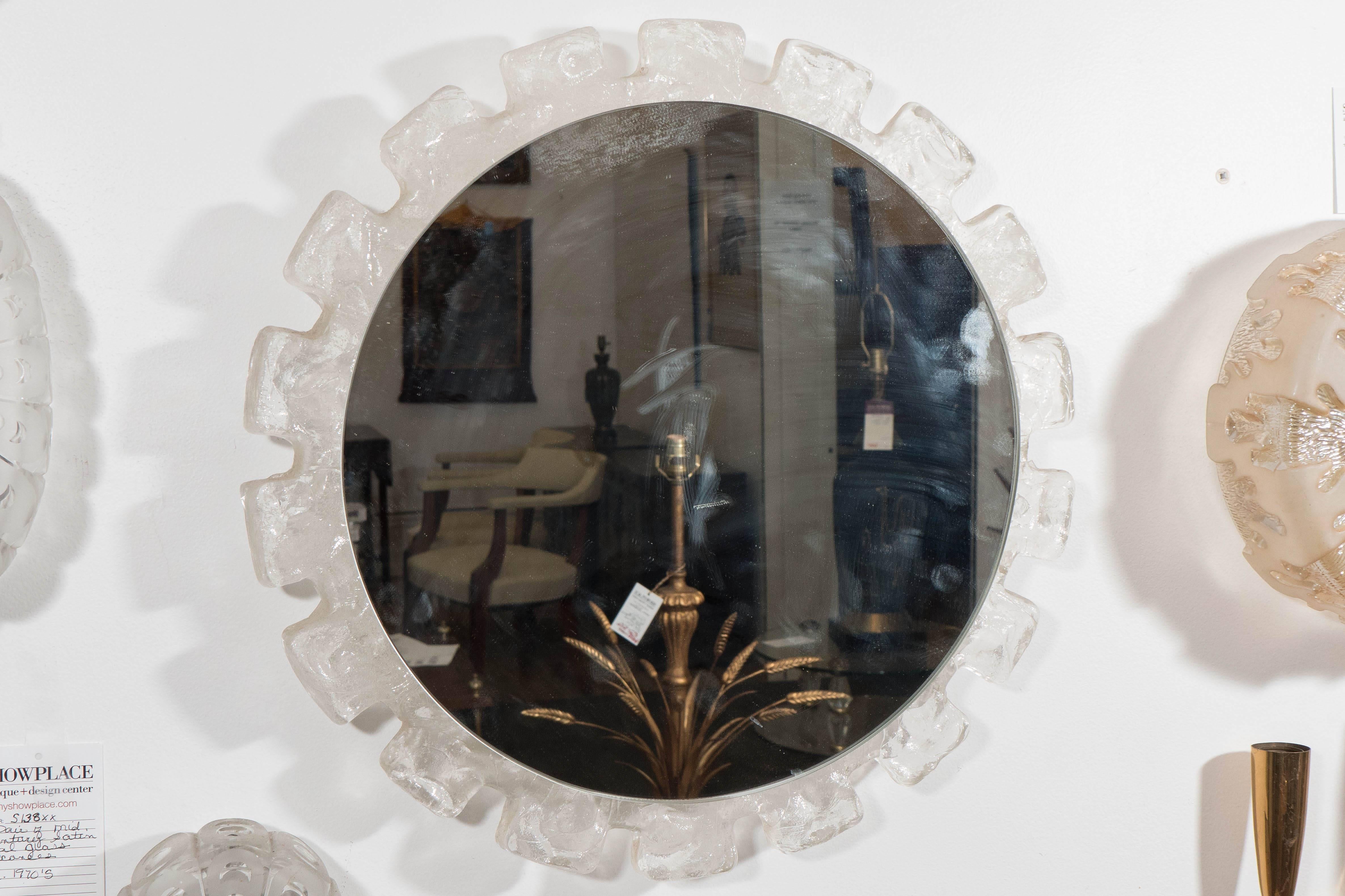 A vintage circular wall mirror, produced circa 1960s, inset within a sunburst frame in Austrian 'Ice Block' textured glass. Very good condition, consistent with age and prior use.